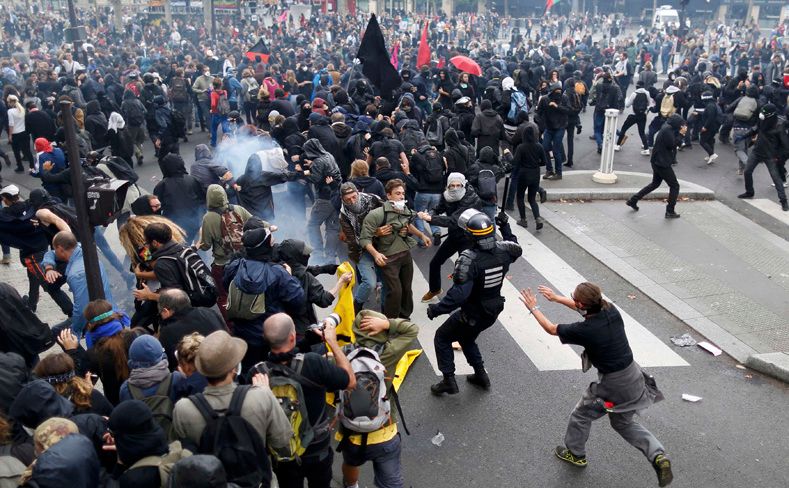 Demonstrators clash with French riot police during a march in Paris